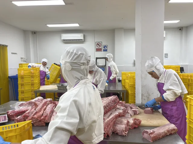 ทีมงานในไลน์ผลิตเนื้อหมูของหมูสมบูรณ์